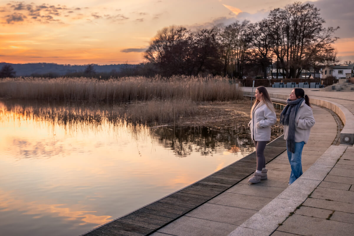 two women walk along level and secure seawall