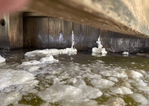 leaking wooden bulkhead with water possibly under dock with foam